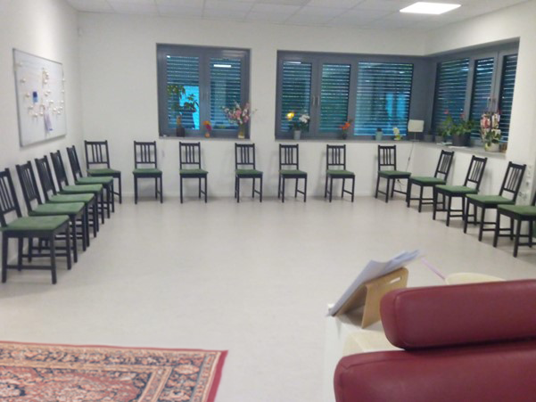 großer Raum mit Sitzkreis aus Stühlen 