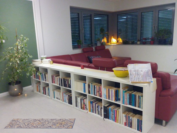 Gemütlicher Raum mit einem tiefgelegten, langen Regal und Couch