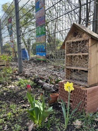 Ein Vogelhaus und eine Blume in einem idyllischen Garten.
